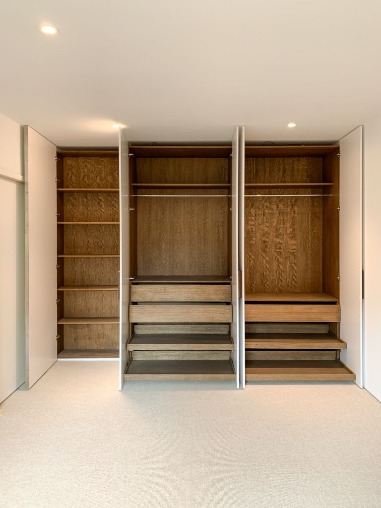 open white wardrobe doors showing walnut lining and drawers